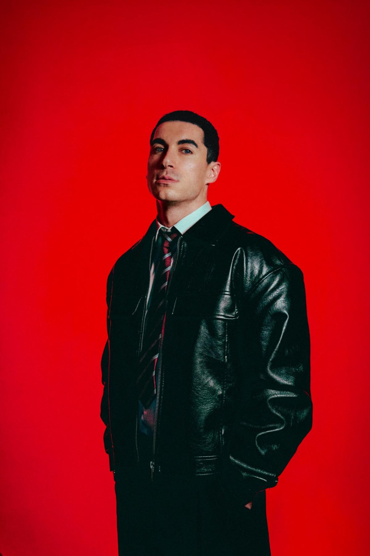 AYVIN en veste de cuir sur fond rouge